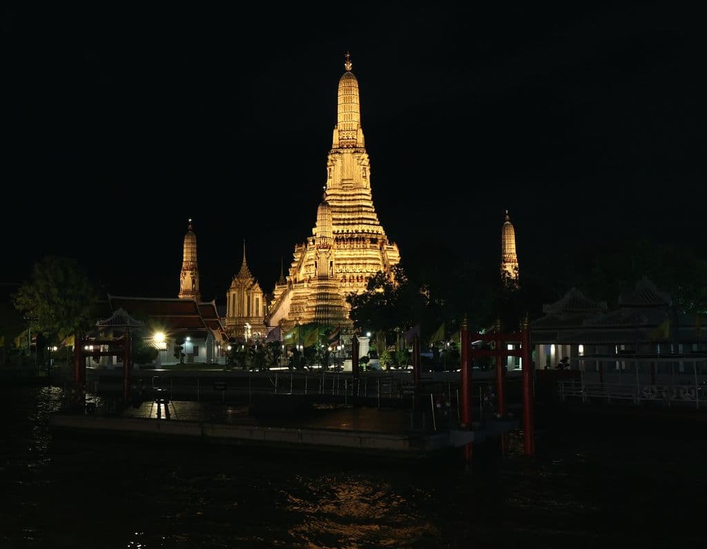 Illuminated Wat Arun at night in Bangkok, by Seneth Dinimuthu