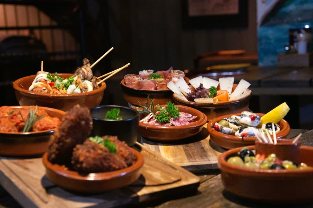 Tapas plates at a busy Barcelona-style bar, by Bas Linders