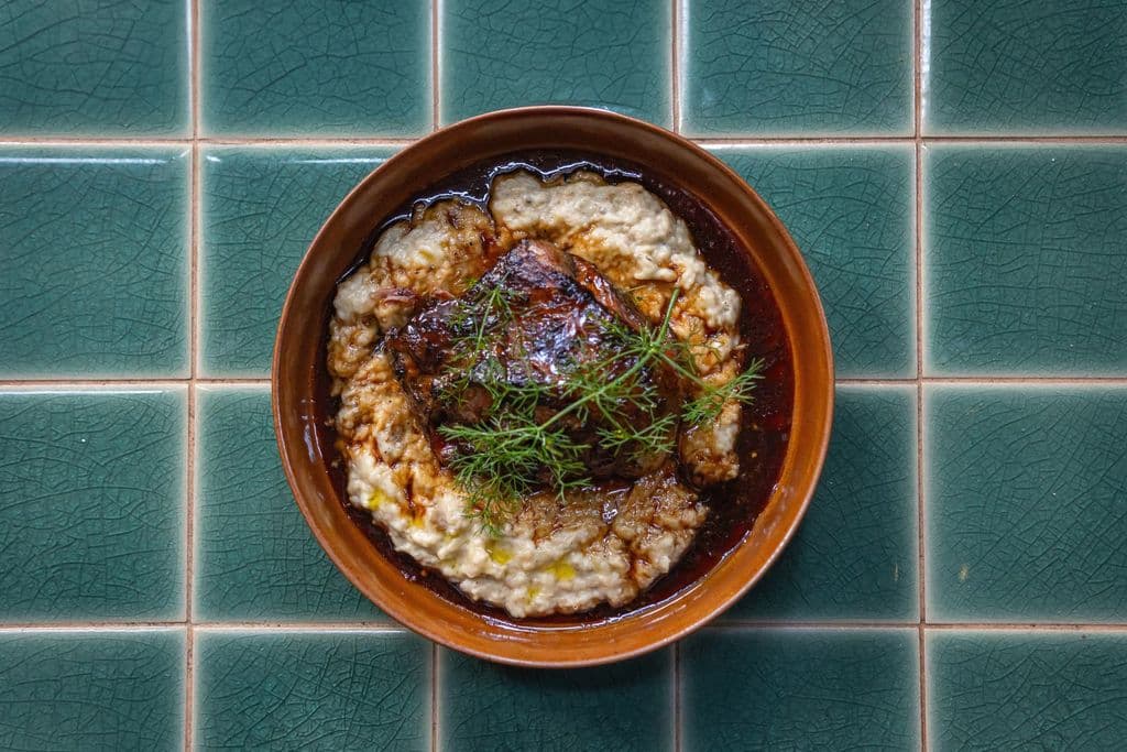 Coq au vin served over mashed potatoes, by Talha Resitoglu
