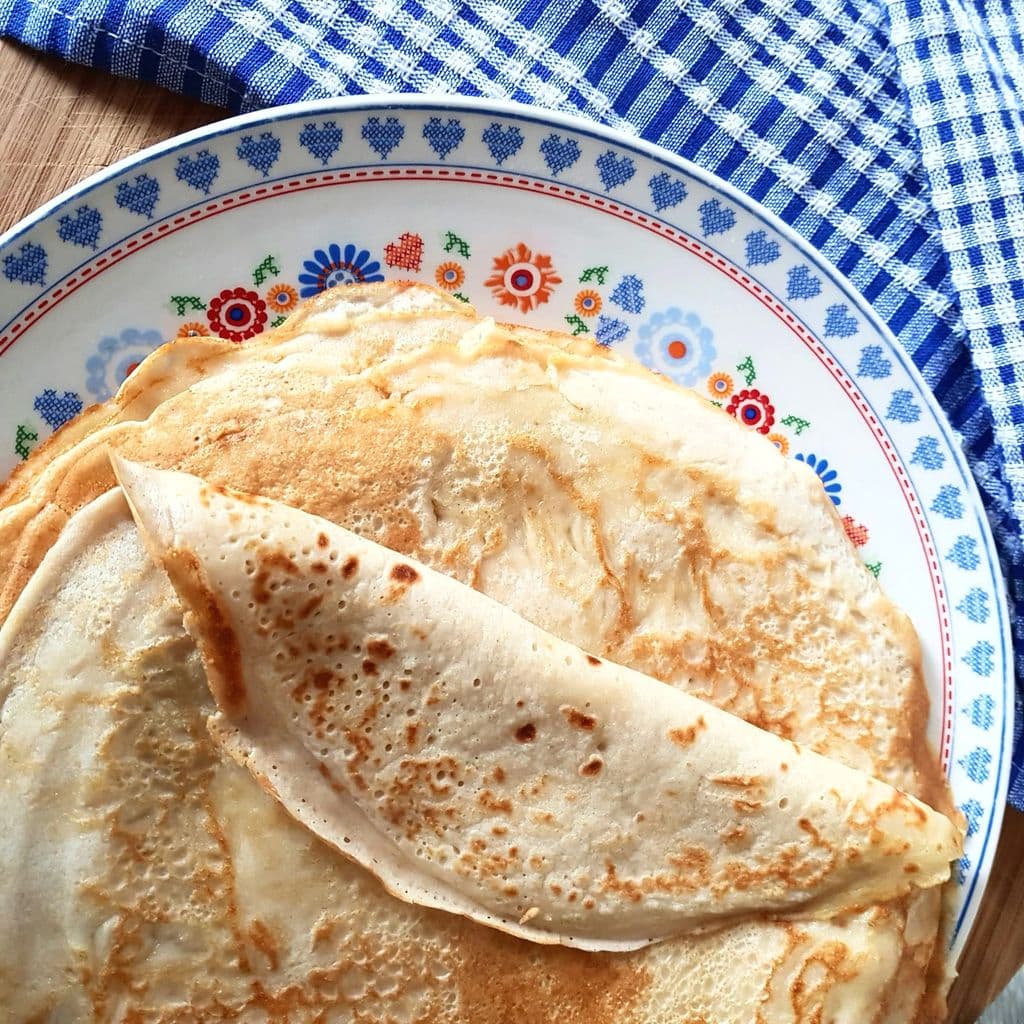 Crêpes on a white and blue plate, by M Draa