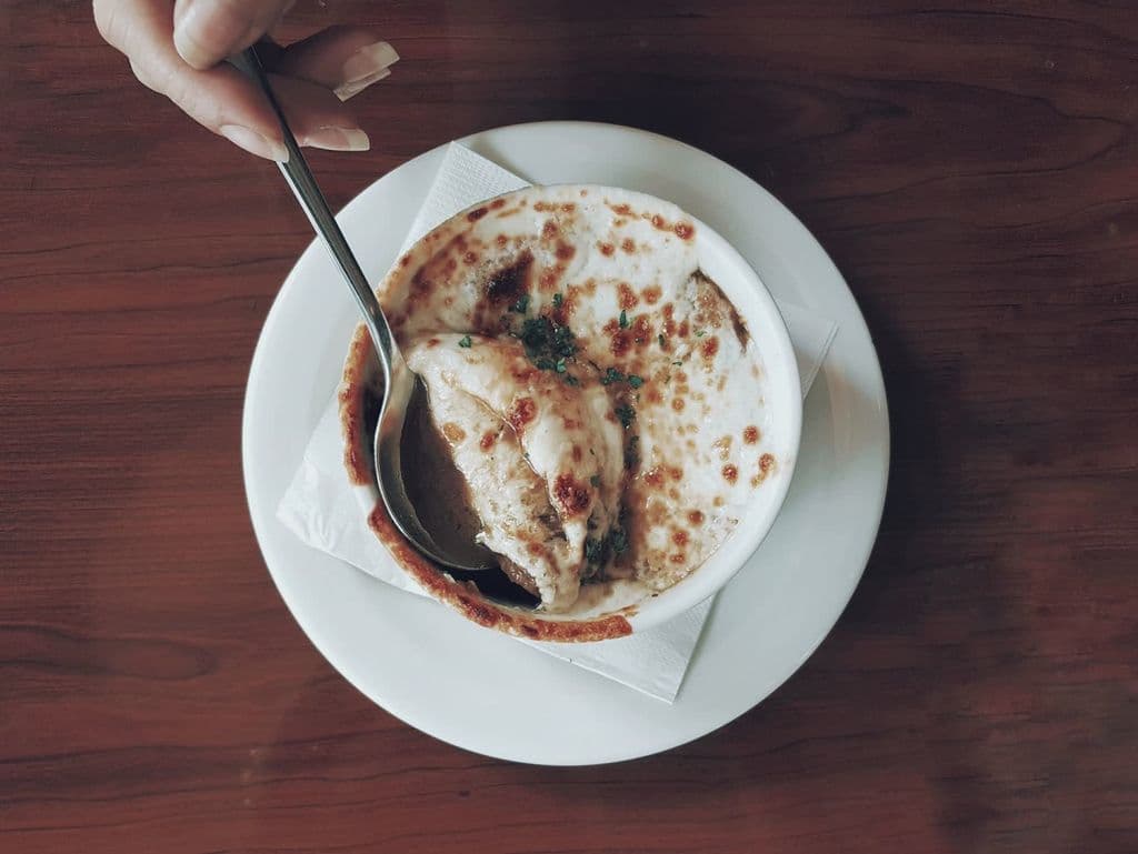 French onion soup with melted cheese in a ceramic bowl, by Maria Isabelle Warren