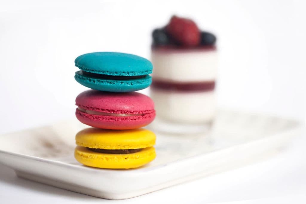 Colorful French macarons stacked on a plate, by Jeffry Surianto