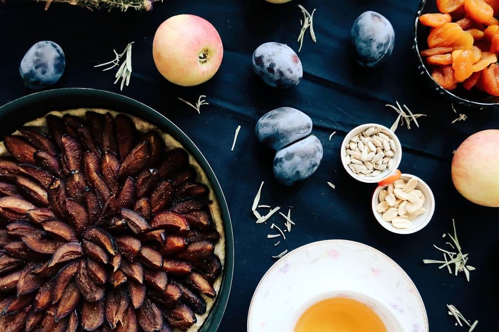 Homemade fruit tarte tatin on a dark table, by Asya Vlasova