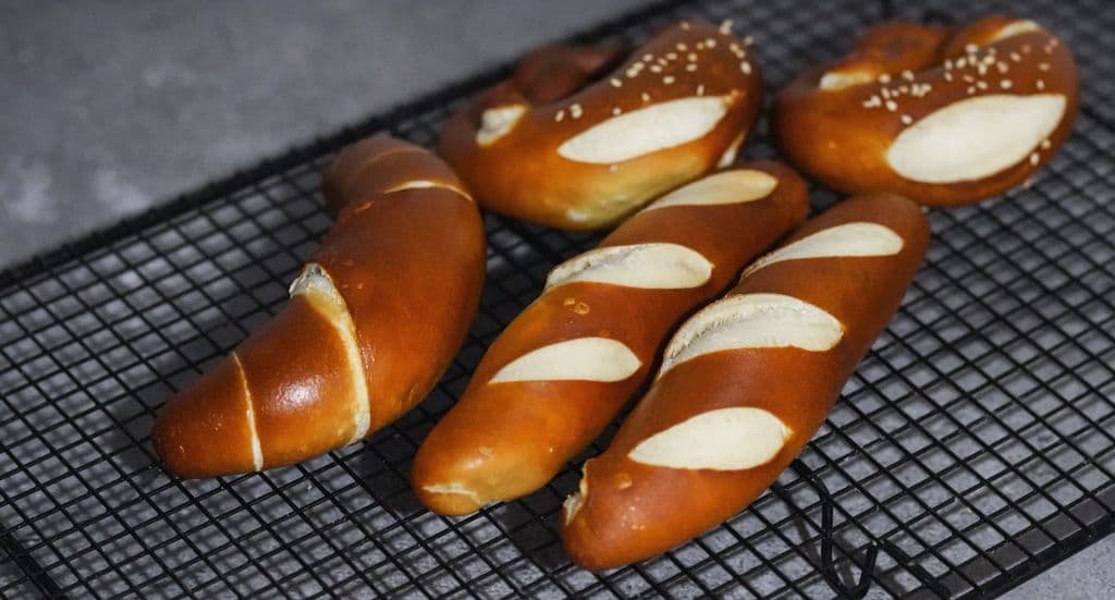 Fresh Bavarian pretzels cooling on a rack, by Cats Coming