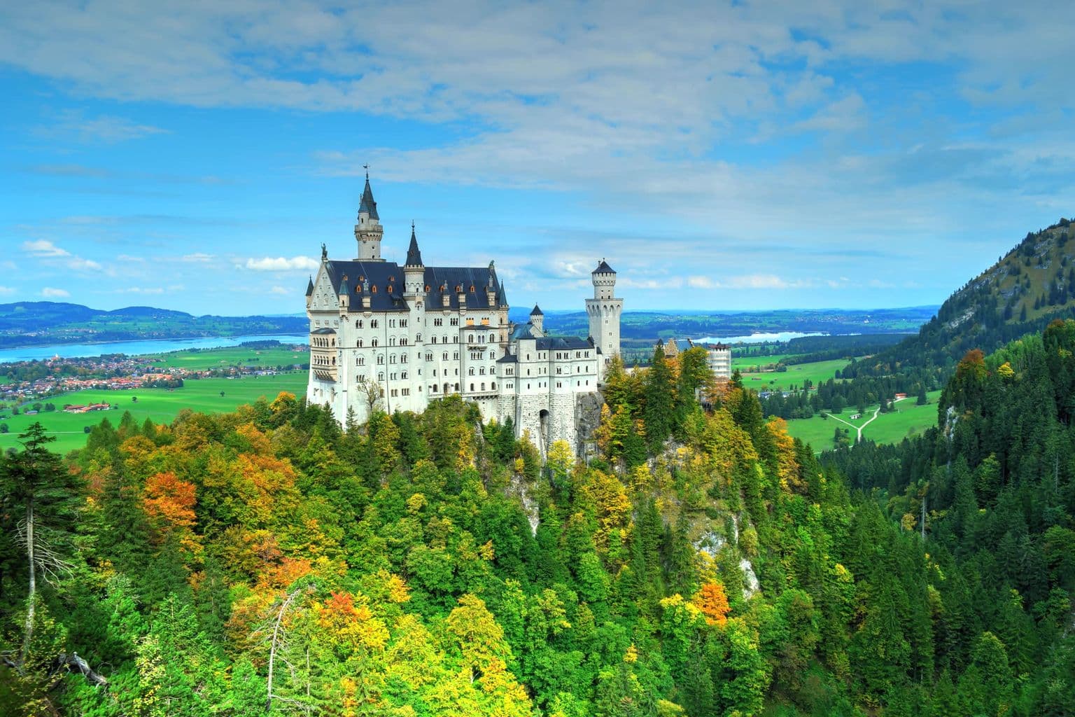 Neuschwanstein Castle above green Bavarian hills in Germany, by Gildo Cancelli