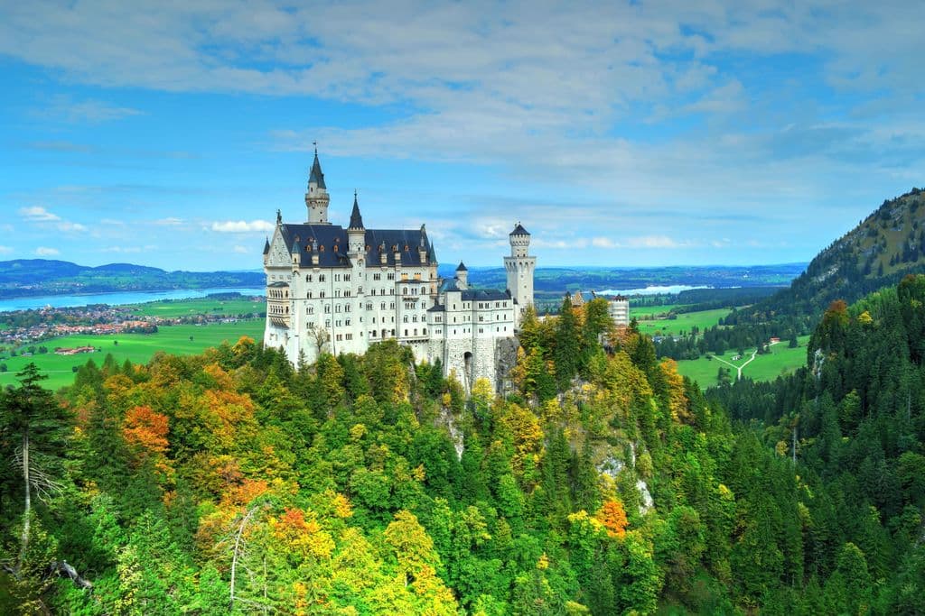 Neuschwanstein Castle above green Bavarian hills in Germany, by Gildo Cancelli