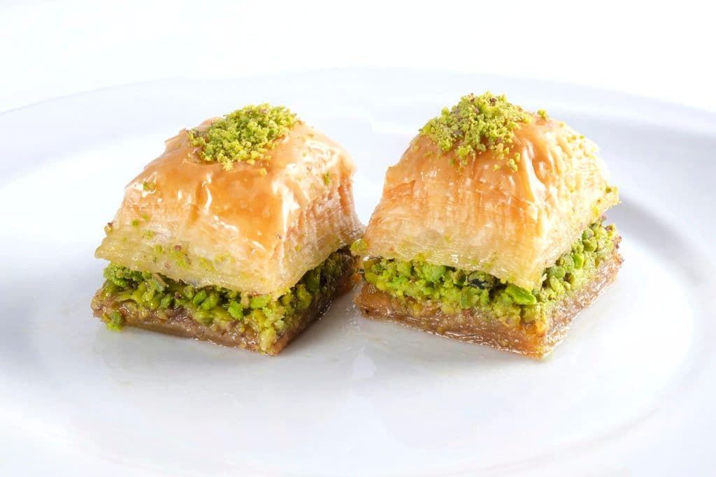 Pistachio baklava pieces on a white plate, by Ömer Haktan Bulut