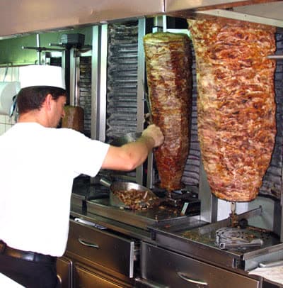 Greek gyros meat on a vertical rotisserie, by Yannis Samatas