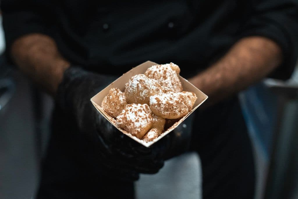 Loukoumades-style fried dough pastries with powdered sugar, by RDNE Stock project