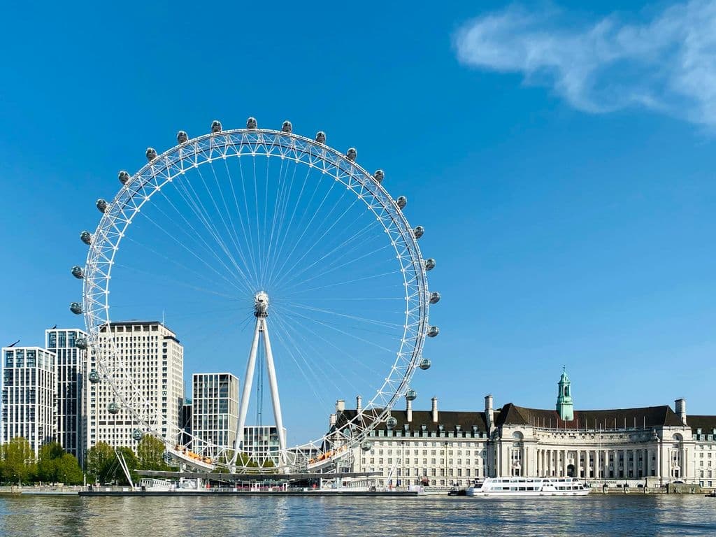 London Eye beside the River Thames under a blue sky, by John Cameron