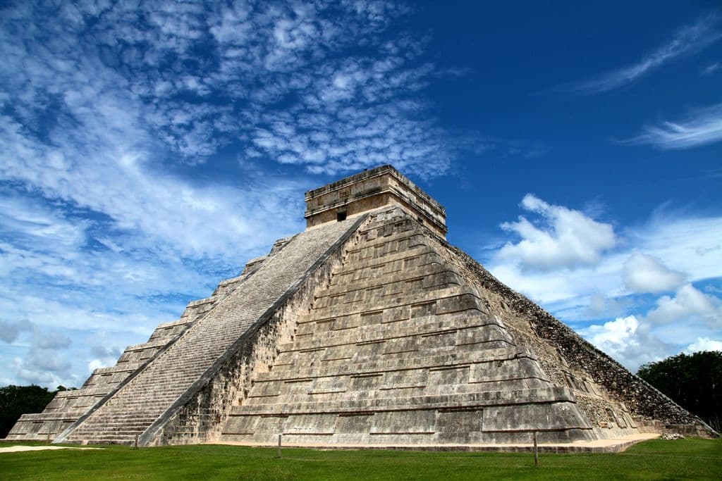 Chichen Itza pyramid under a blue sky in Mexico, by Mario La Pergola