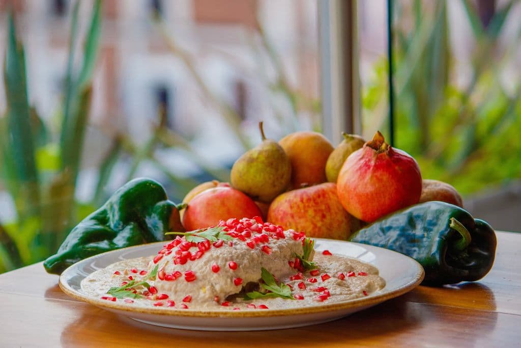 Chile en nogada with pomegranate and peppers, by Aurora León