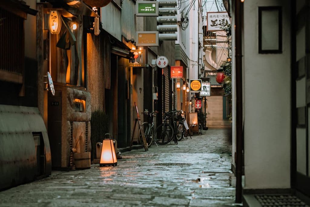 Lantern-lit cobblestone alley in Osaka, by Satoshi Hirayama