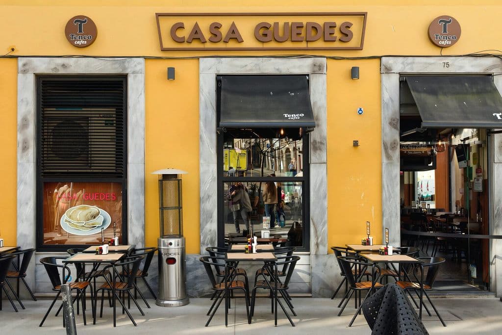Casa Guedes yellow facade and outdoor seating in Porto, by Eric Prouzet