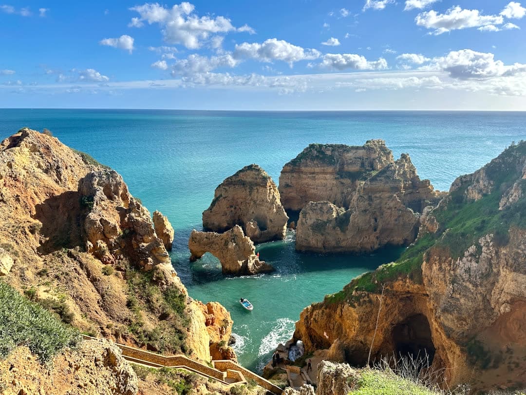Sunny sea cliffs and turquoise water in the Algarve, Portugal, by Sokmean Nou