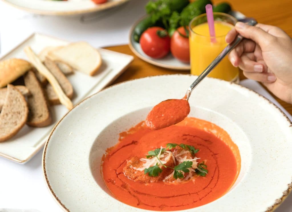 Bowl of red gazpacho with garnish, by Farhad Ibrahimzade