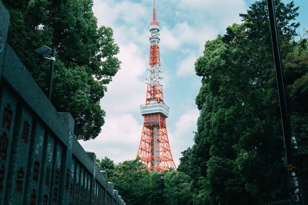 Tokyo Tower surrounded by greenery on a clear day, by Michael Li