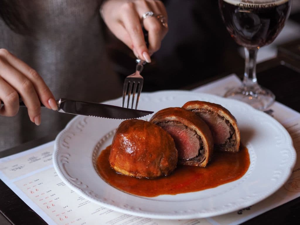 Sliced Beef Wellington on a plate, by Nadin Sh