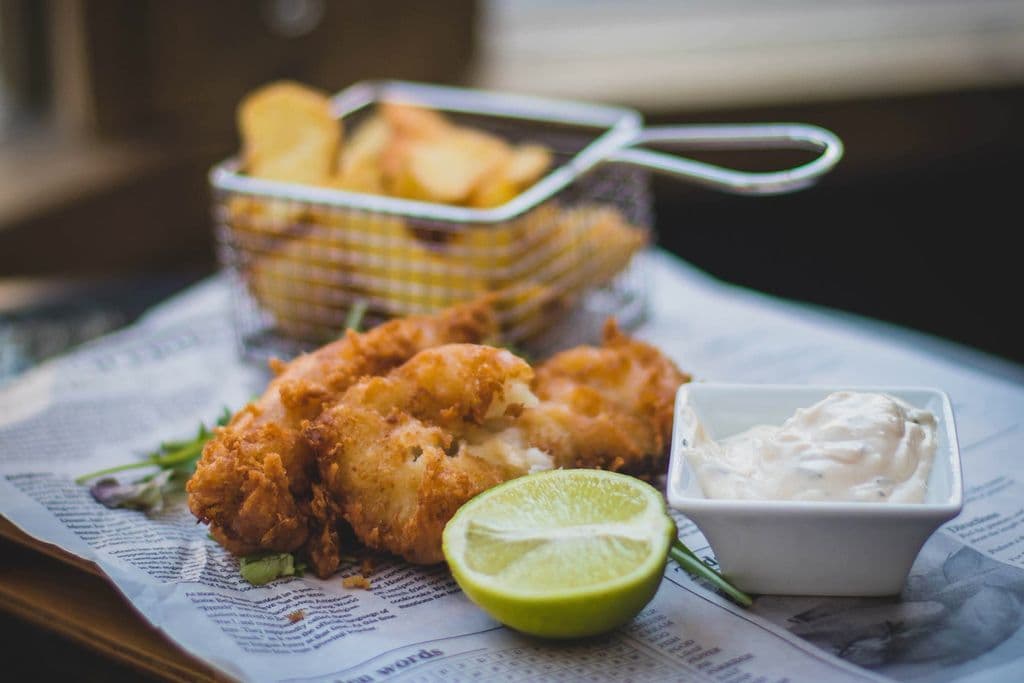 Plate of fish and chips with sauce and lime, by Valeria Boltneva
