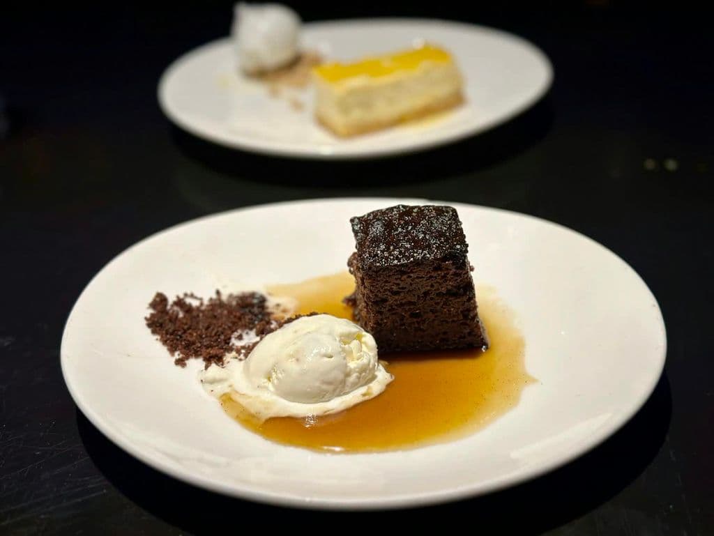Sticky toffee-style dessert plates on a table, by Brett Wharton