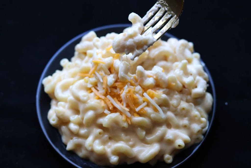 Creamy mac and cheese on a black plate, by Barbara G