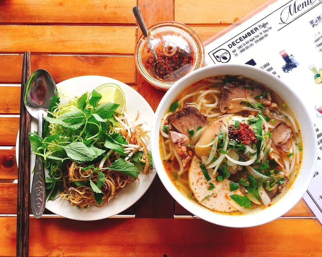 Bún bò Huế style noodle soup with herbs and rich broth, by JANG S