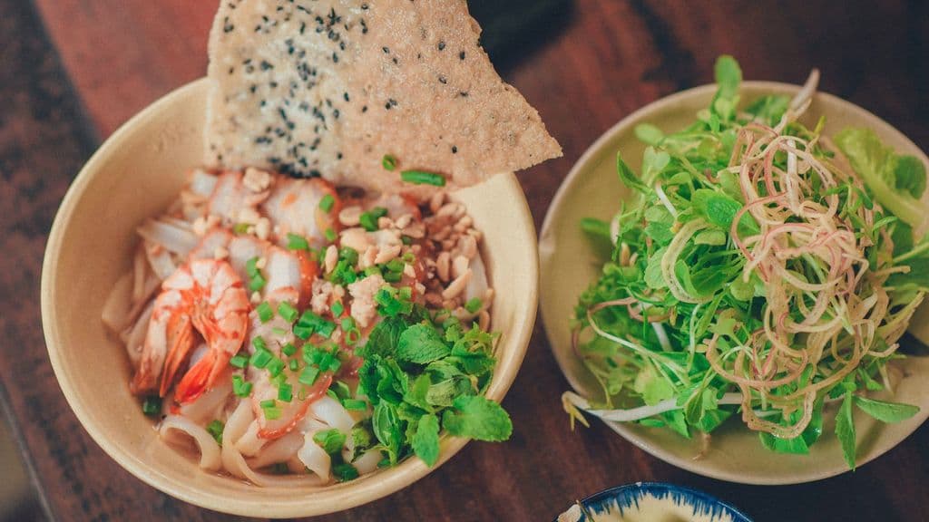 Vietnamese cao lầu style noodle bowl with herbs and greens, by Min An